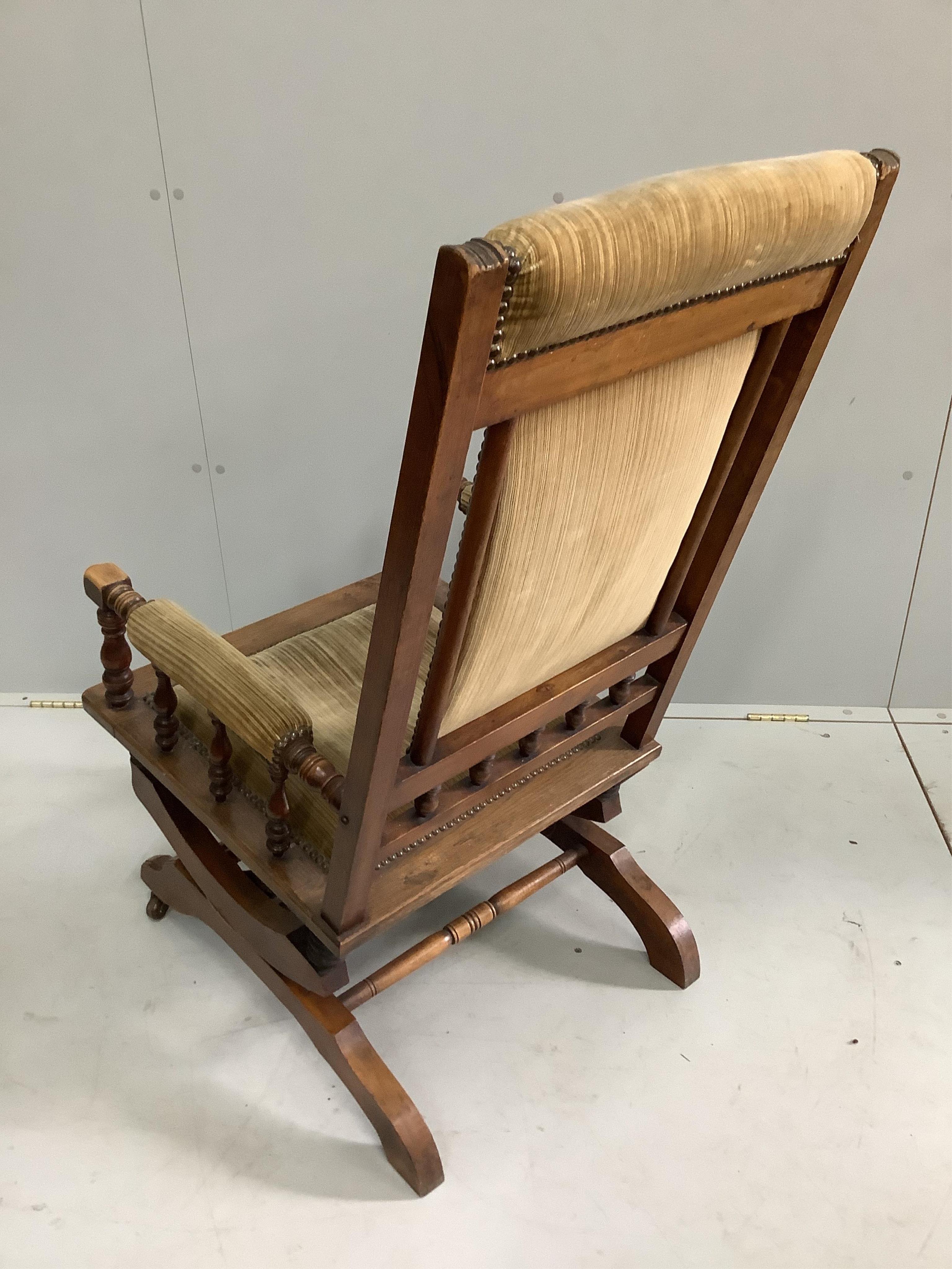 A late 19th century American oak and beech upholstered rocking chair, width 58cm, depth 54cm, height 106cm. Condition - fair